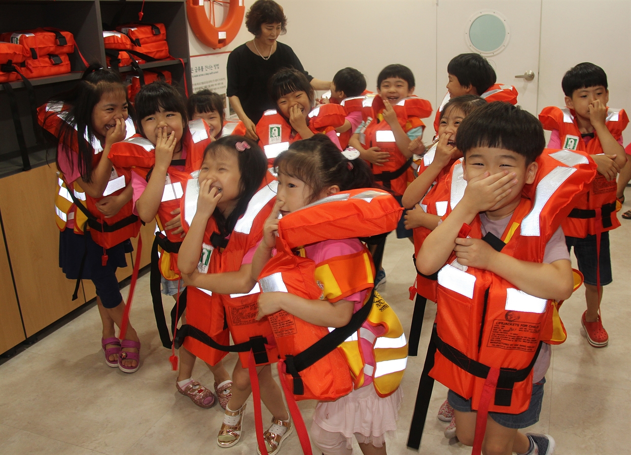  월랑초 병설유치원 만 6세반 원생들이 구명조끼를 입고 바닷물에 뛰어내리는 체험훈련을 하고 있다.   