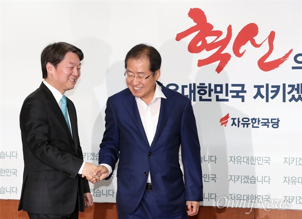 자유한국당 홍준표 대표가 지난 8월 29일 오전 서울 여의도 당사를 방문한 국민의당 안철수 대표와 인사한 뒤 자리로 향하고 있다.