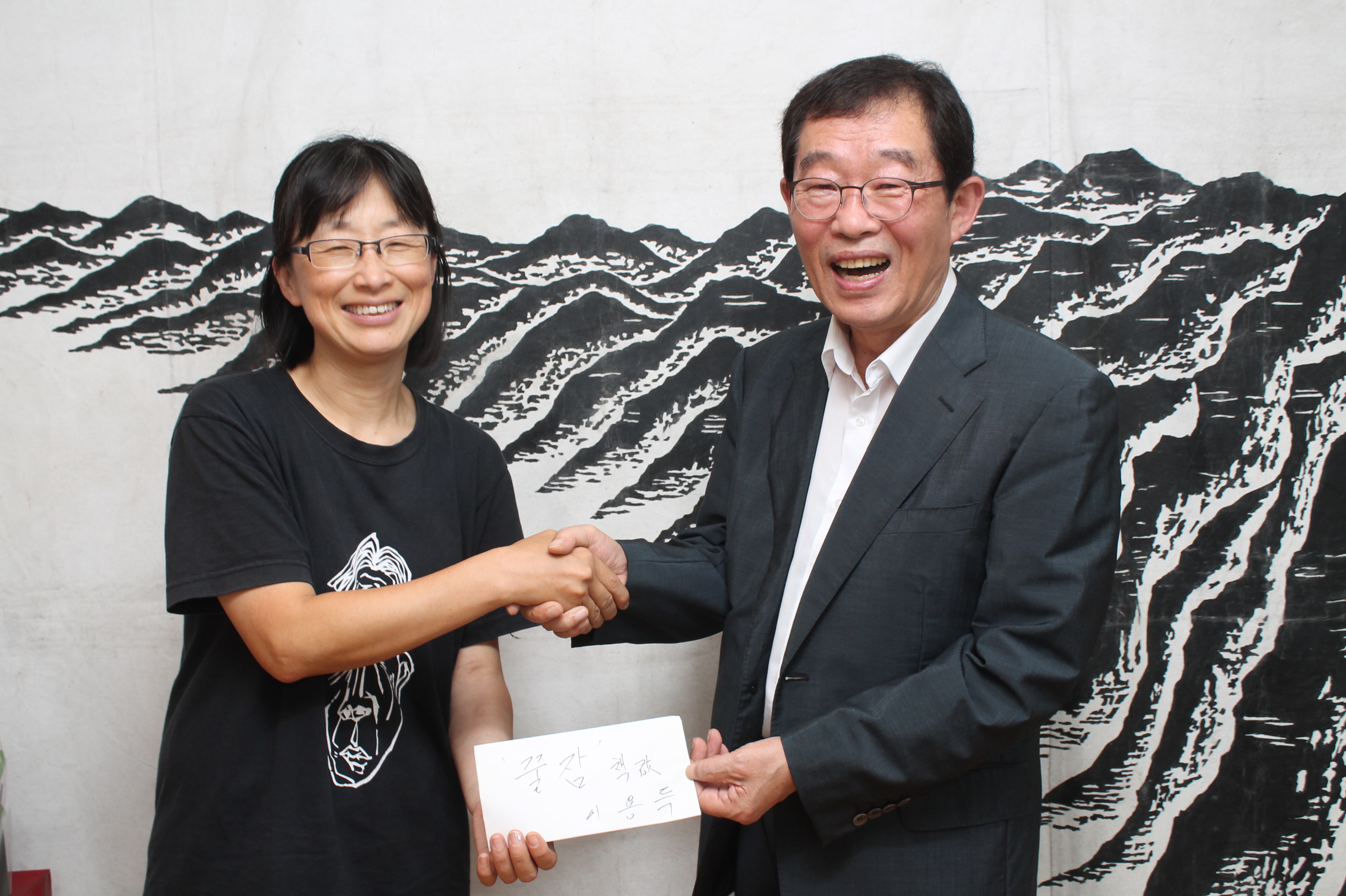 이용득 의원이 김소연 비정규노동자의 쉼터 꿀잠 운영위원장에게 500만원을 전달했다. 대담집 <두 어른>을 사전 구매하기 위해서다.