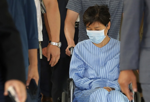 환자복을 입은 박근혜 전 대통령이 지난 8월 30일 서울 서초동 서울성모병원에서 허리 통증으로 진료를 받은 뒤 휠체어를 타고 병원을 나서고 있다.
