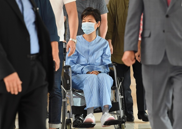 환자복을 입은 박근혜 전 대통령이 30일 서울 서초동 서울성모병원에서 허리 통증으로 진료를 받은 뒤 휠체어를 타고 병원을 나서고 있다.