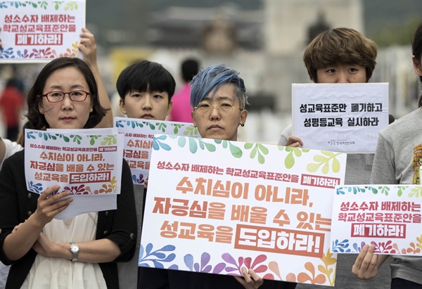 2017년 8월 30일 오전, 서울 광화문광장에서 열린 ‘국가수준의 학교성교육 표준안 폐기를 위한 16,698명 서명 제출 기자회견’에서 참석자들이 성소수자 배제하고 성차별하는 학교성교육표준안 폐기를 촉구하는 내용의 피켓을 들고 있다.