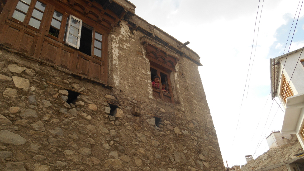 오래된 건물에서 얼굴을 내밀고 있는 라다크 레의 아이들.