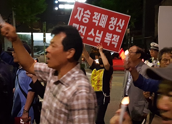 거리행진 이날 거리행진 중 한 참석자가 '자승적폐청산, 명진스님 복적'등의 팻말을 들고 조계사로 향하고 있다.