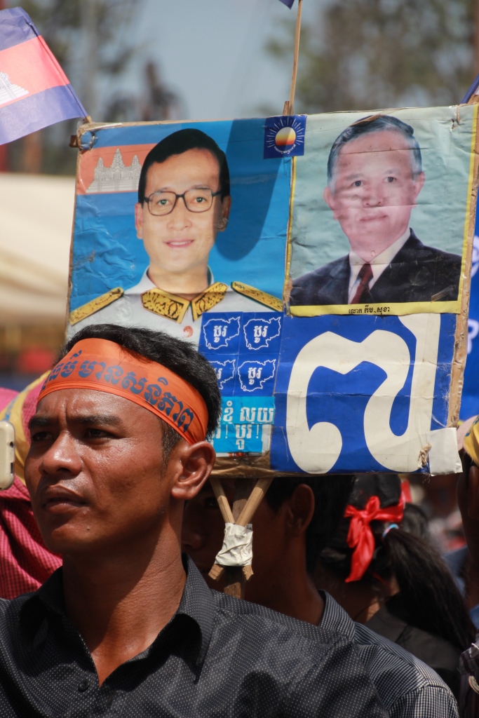 캄보디아 제1야당 구국당(CNRP)의 두 지도자 삼 랭시와 켐 소카의 사진을 들고 있는 야당지지자의 모습.