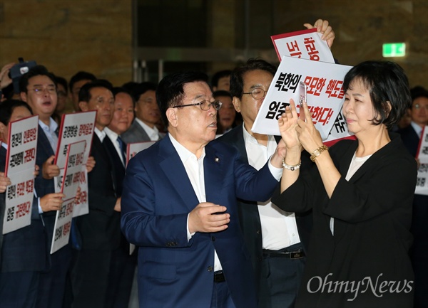 더불어민주당 손혜원 의원이 지난 4일 오전 국회 본회의장 입구에서 피켓 시위를 하고 있는 자유한국당 의원들의 모습을 생중계하자, 자유한국당 심재철, 김광림 의원이 이를 막아서고 있다. 