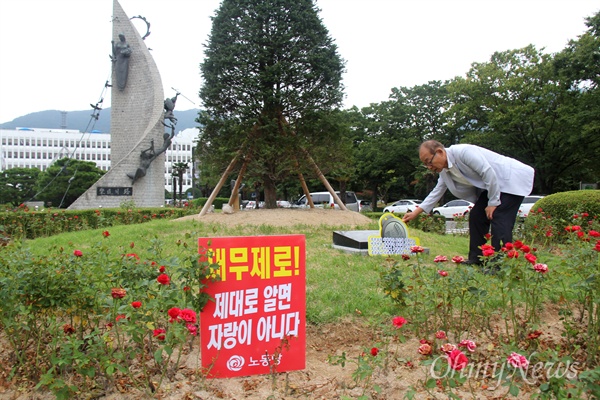  김영만 '적폐청산과 민주사회건설 경남운동본부' 상임의장이 6일 오후 경남도청 정문 앞에서 홍준표 전 경남지사가 심어놓은 '채무제로 기념식수' 나무를 철거하라는 내용으로 하루 전날 박아 놓은 팻말을 살펴보고 있다.