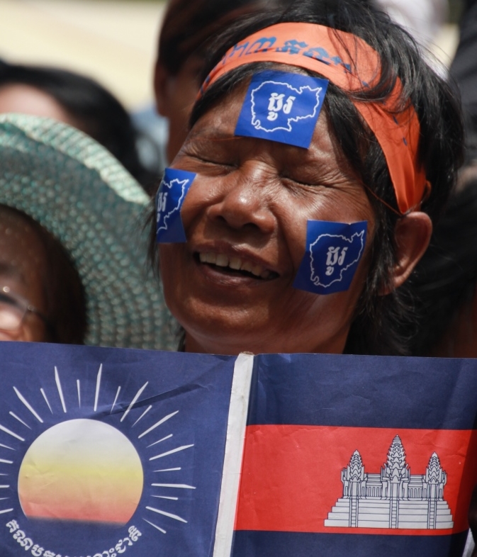 야당깃발과 캄보디아국기를 양손에 든 채 고통스러운  표정을 짓고 있는  캄보디아 야당지지자의 모습. 캄보디아가 민주주의국가로 가는 길이 무척이나 험난해 보인다. 