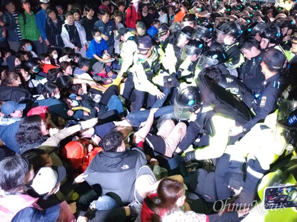 지난 7일 오전 경북 성주군 초전면 소성리 마을회관 앞에서 경찰이 사드 반입에 반대하는 주민들을 끌어내고 있다.