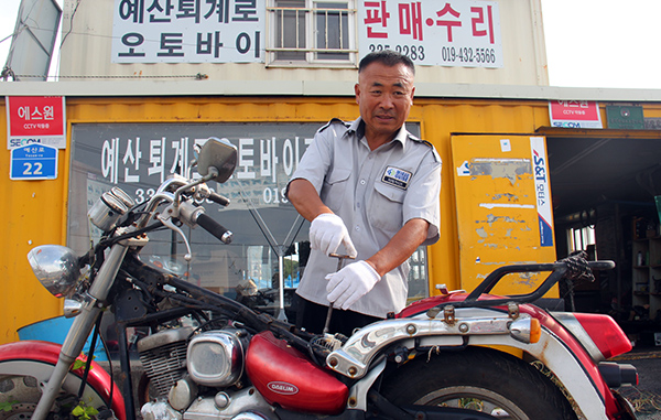 이회관 사장이 퇴계로오토바이센터 앞 마당에서 오토바이 수리를 하고 있다. 