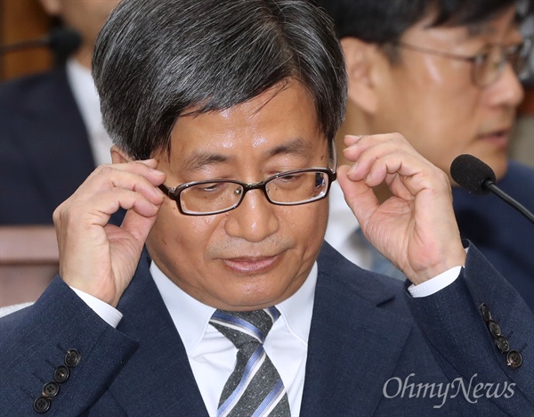 김명수 대법원장 후보자가 지난 12일 국회 인사청문회에 출석해 안경을 고쳐쓰고 있다. 