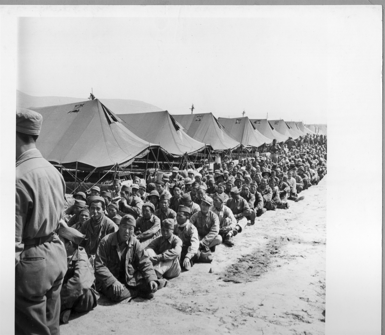   1951. 4. 중국군 포로들이 막사 밖에서 인원 점호를 받고 있다.