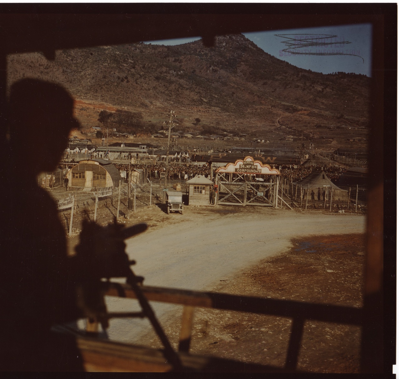  1952. 3. 20. 거제포로수용소. 한 포로감시병이 포로감시초소 기관총 앞에서 중국군 포로수용소를 경계하고 있다.
