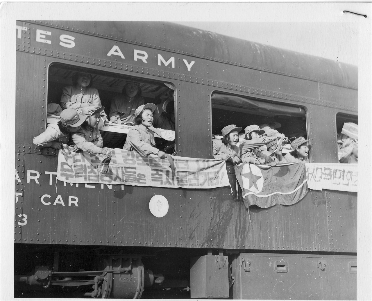  1953. 8. 6. 북한으로 돌아가는 인민군(여) 포로들이 열차 밖으로 인공기와 플래카드를 내걸고 구호를 부르짖고 있다. 