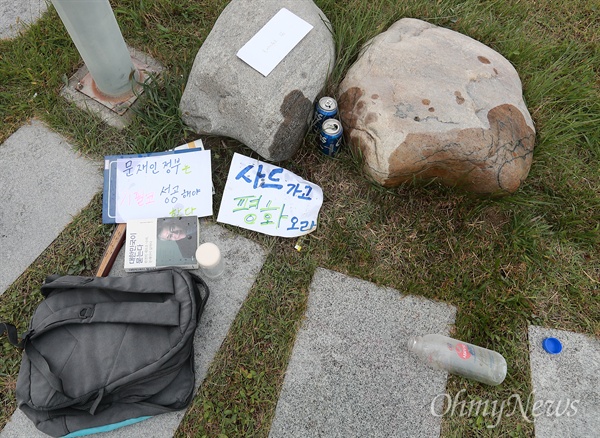  19일 오후 서울 마포구 상암동 누리꿈스퀘어 18층 야외정원에서 한 시민이 사드배치에 반대하며 분신한 가운데, 분신한 곳 주변에 ‘사드가고 평화오라’ ‘문재인 정부는 기필코 성공해야 한다’가 적힌 종이와 ’대한민국이 묻는다(완전히 새로운 나라, 문재인이 답하다)’ 책, 기름을 담았던 병, 편지봉투, 가방이 놓여 있다.