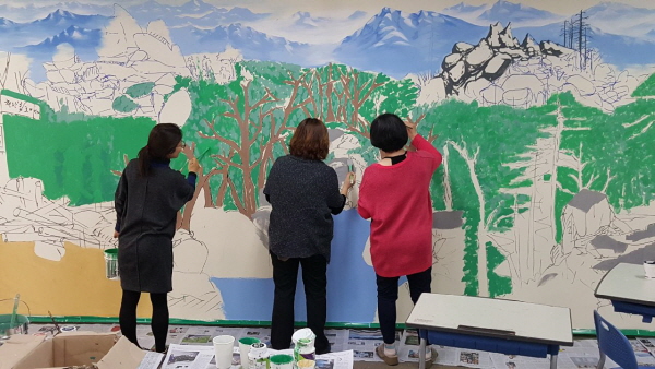 서 작가가 그린 해밀학교 각 반 뒷벽 벽화 작품에 선생님들이 함께 참여해 색을 입히고 있다. 사진제공=해밀학교