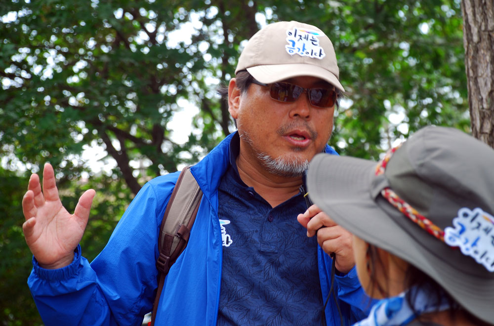 소설 <금강>의 김홍정 작가가 김관진 시인의 <이 가을에>란 시비 앞에서 설명하고 있다.