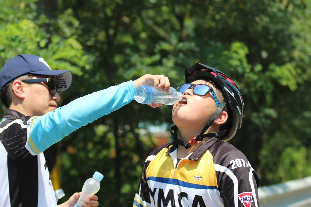 오르막 구간을 오르다 지친 참가자들에게 물을 나눠주고 있다
