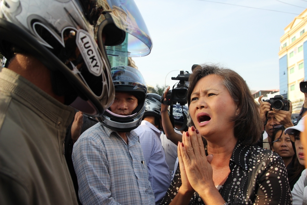 캄보디아 제1야당 부총재 무 소쿠아 의원이 오토바이헬멧을 쓴 진압경찰들을 향해 무고한 시민들을 폭행하지 말아달라고 간절히 부탁하고 있다. (2014년 1월 프놈펜 법원앞 )  