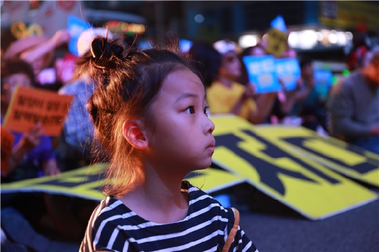 저녁 늦게까지 이어진 탈핵 집회에서 진지하게 연설을 듣고 있는 어린이