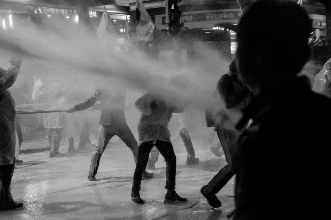2015년 11월 14일 민중총궐기 당시, 차벽을 당기던 시민들이 경찰이 쏜 물대포를 맞고 있다.