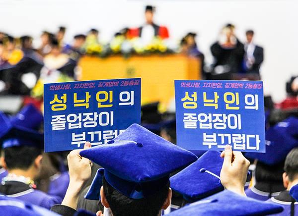 지난 2월 서울대 71회 학위수여식에서 성낙인 총장이 축사를 할 때 졸업생이 '성낙인의 졸업장이 부끄럽다'는 피켓들 들여보이고 있다.
