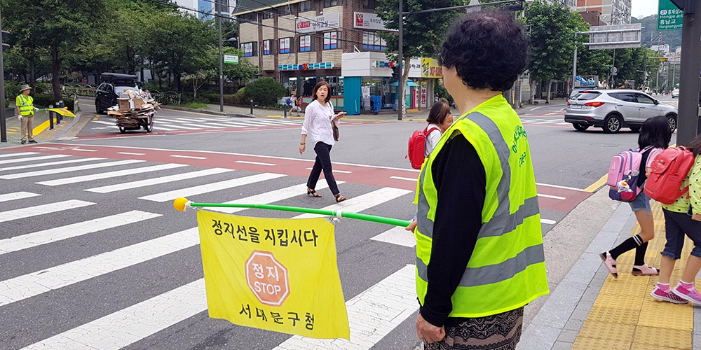 9월 6일 오전 서울가재울초 정문 앞 횡단보도에서 교통지도를 하고 있는 어르신.