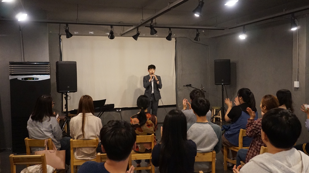 공유공간 팩토리얼에서 뮤지컬 배우겸 가수 더블제이가 노래를 부른 후 관객에게 환호성을 받고 있다.