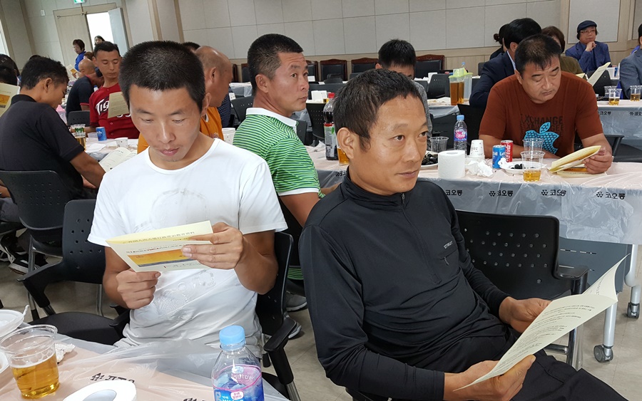  중국어로 된 출입국 행정 상식이 교육자료로 배포되고, 참가자들은  이 자료를 설명하는 ‘토크콘서트’를 경청하고 있다.