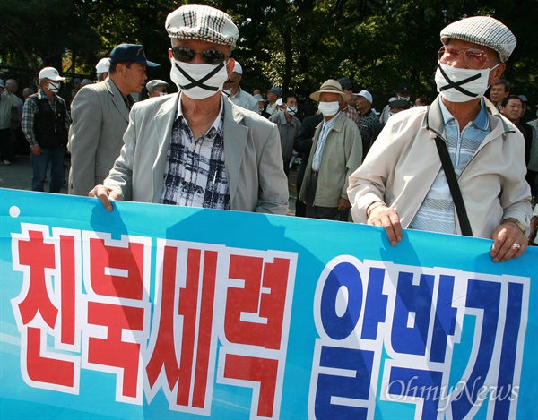  마스크를 쓰고 현수막을 들고 있는 대한민국어버이연합, 한미우호증진협의회 회원들.