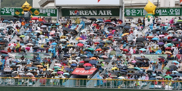  15일 오후 롯데 자이언츠와 NC 다이노스의 준플레이오프 5차전이 열리는 부산 사직야구장에 비가 내리면서 야구팬들이 우산을 쓰고 경기 시작을 기다리고 있다.