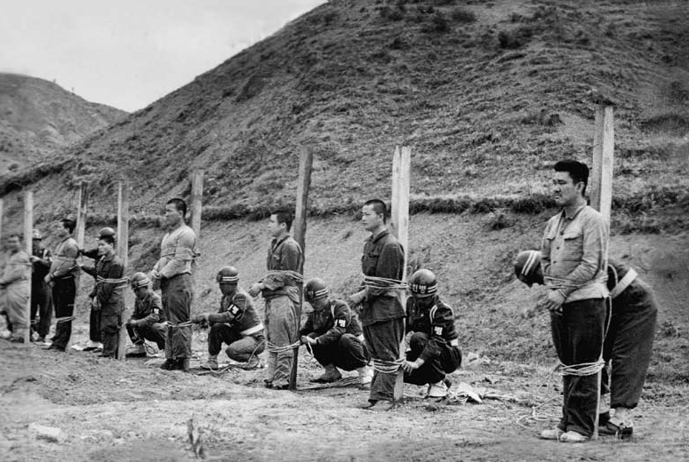 헌병들이 사형수들을 형틀에 새끼로 묶고 있다.
