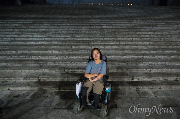 장애인 활동가 문애린씨가 서울 종로구 세종문화회관 앞 계단 앞에 이동 수단인 전동휠체어에 앉아 있다. 