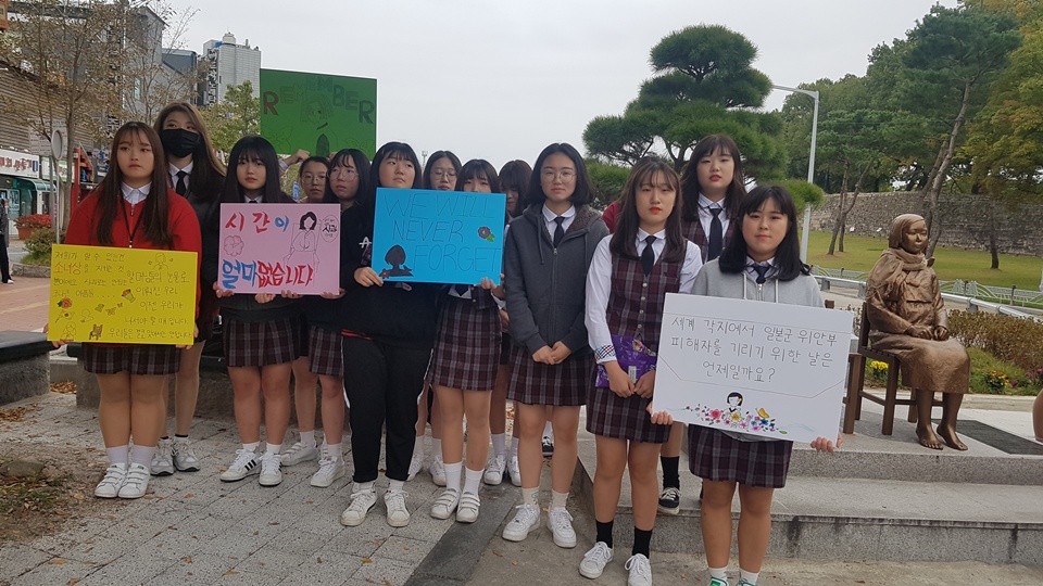 홍성여고 학생들은 18일 오후 '홍성 평화의 소녀상'앞에서 위안부 피해자를 생각하고 과거를 절대 잊지 말자며, 손팻말과 함께 지나가는 시민들에게 캠페인을 하고 있다. 