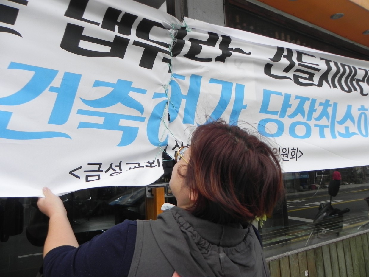 지난 달 '교회 신축 반대 주민대책위원회' 주민들이 7층 교회 신축을 반대하는 현수막을 걸었다. 6장 중 5장이 다음날 사라졌고1개는 찢어져 버려진 것을 발견했다. 주민들이 그것을 꿰매서 다시 걸었다. 