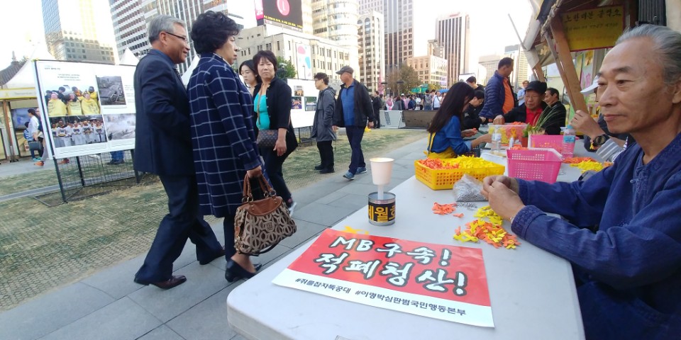 21일 서울 광화문광장에서 자원봉사자들이 세월호 리본을 묶고 있다. 