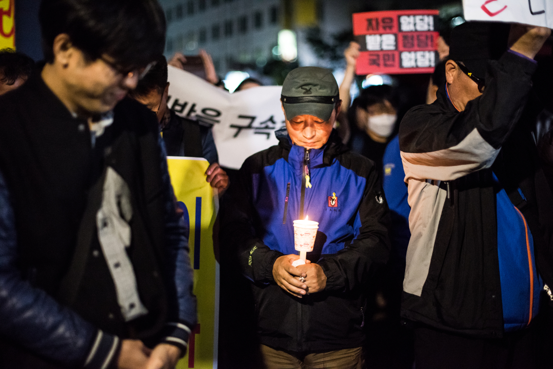 자유한국당 당사 앞에서 묵념하는 '촛불파티' 참가자들 '촛불파티' 참가자들이 자유한국당 당사 앞에서 묵념하고 있다.