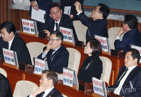 피켓 붙인 한국당 문재인 대통령이 1일 오전 서울 여의도 국회 본회의장에서 새해 예산안 제출에 따른 시정연설을 하는 동안 자유한국당 정우택 원내대표 등 의원들이 '민주주의 유린 방송장악 저지'라고 적힌 피켓을 모니터에 붙이고 있다.