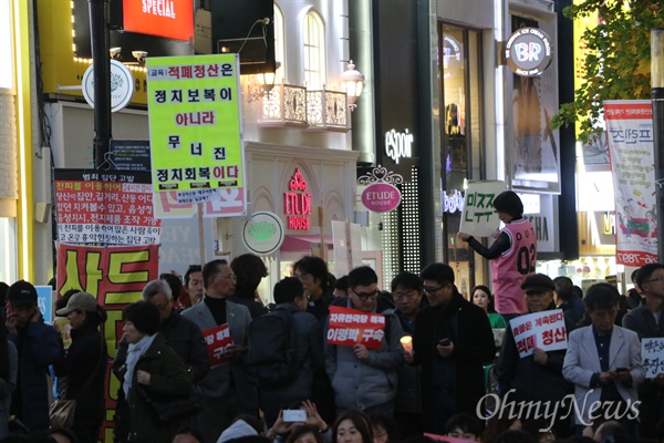 박근혜 대통령퇴진을 요구하며 촛불을 들었던 대구시민들이 1주년을 맞아 4일 오후 동성로 대구백화점 앞에서 다시 촛불을 들었다. 한 시민이 '적폐청산은 정치보복이 아니라 무너진 정치회복이다'라고 쓴 피켓을 들고 있다.