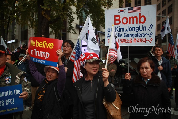 '김정은 제거 폭격' 주장하는 보수단체 대한애국당과 보수단체 회원들이 7일 오후 서울 종로구 청계광장에서 열린 '트럼프 미국대통령 방한 기념 한미동맹 강화 및 박근혜 대통령 정치투쟁 지지 태극기 집회'에서 북한 독재를 규탄하며 '김정은 깡패 소굴 폭격하자' 피켓을 들어보이고 있다.