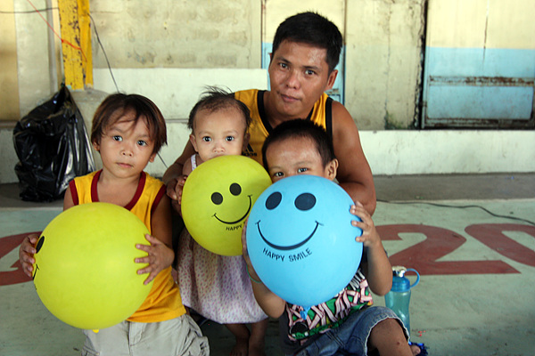 세명의 어린아이를 데리고 진료받으러 온 필리핀 현지인이 선물 받은 풍선을 들고 기념촬영했다