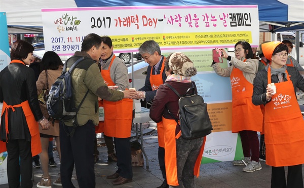 박종훈 경남도교육감이 11일 창원 정우상가 앞에서 열린 ‘가래떡 데이 사랑 빚을 갚는 날’ 캠페인에서 가래떡을 시민들한테 나눠주고 있다. 