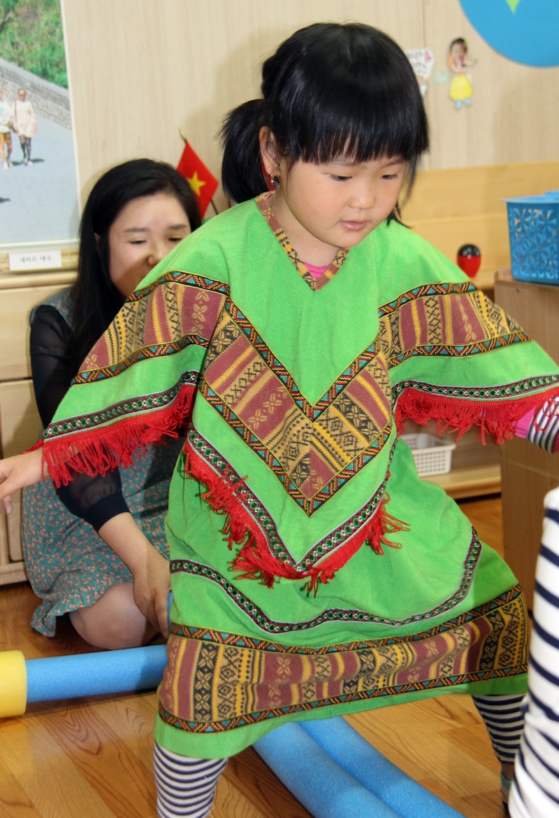 한 아이가 다른 나라의 전통복장으로 놀이를 하고 있다. 