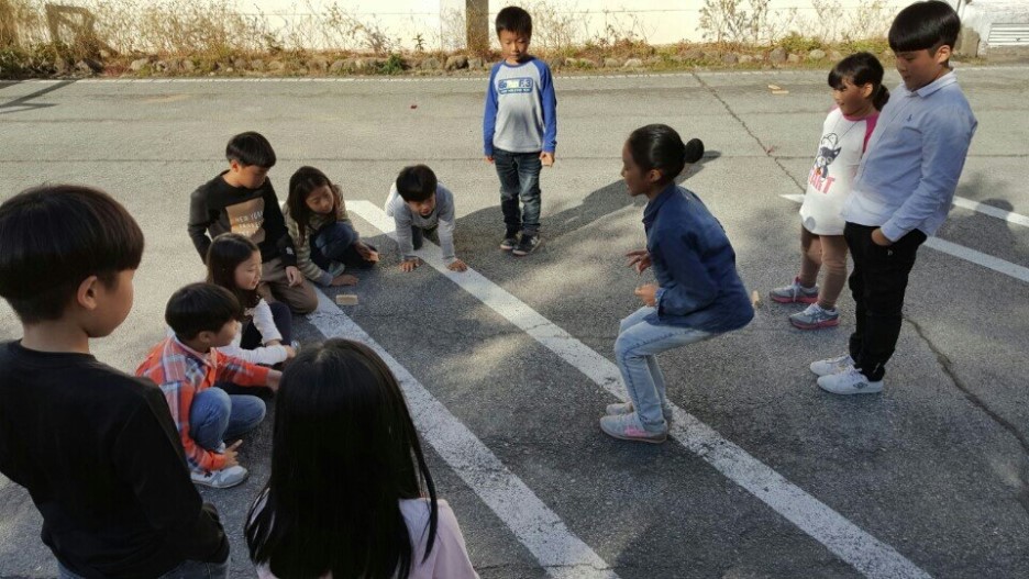 수업이 끝난 후 비석치기 하는 아이들