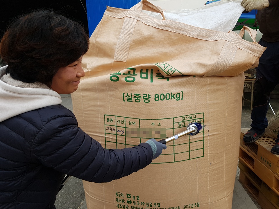  국립농산물품질관리원 홍성.청양사무소 직원이 벼 등급 판정이 끝나고 포대에 등급을 표시하고 있다.