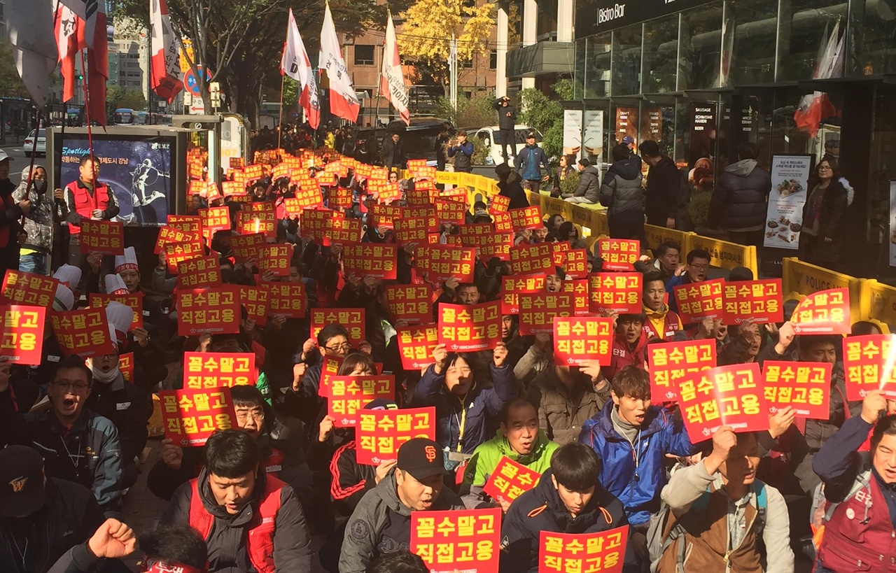 화학섬유연맹 조합원들과 정의당 당원들이 강남 SPC스퀘어 앞에서 집회를 하고 있다. '꼼수말고 직접고용' 손피켓을 들고 구호를 외치고 있다.