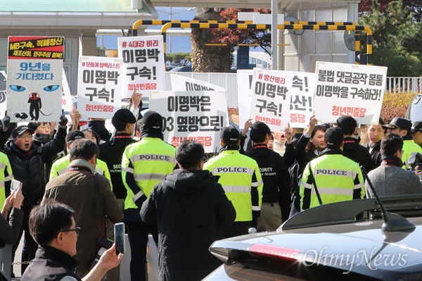 이명박 전 대통령이 바레인 방문을 마치고 15일 오전 인천공항을 통해 귀국하자 시위대가 이 전 대통령 차량을 향해 "이명박 구속하라" 피켓을 치켜들고 있다. 
