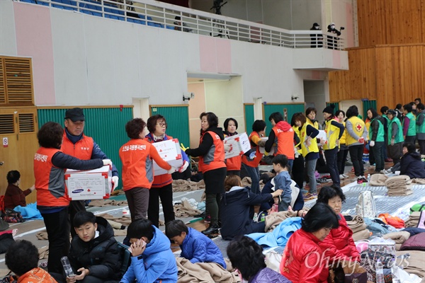 적십자사 회원들과 자원봉사자들이 16일 오전 포항 흥해실내체육관에서 지진으로 대피한 주민들에게 구호물품을 나눠주고 있다.