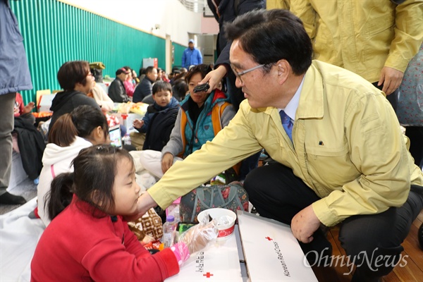 우원식 원내대표가 16일 오전 포항 흥해실내체육관에서 김밥을 먹고 있는 어린이를 위로하고 있다.