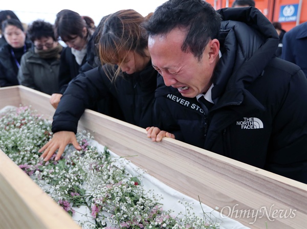 세월호 미수습자 남현철 학생의 아버지 남경원씨(맨오른쪽)와 가족들이 18일 오전 목포신항 세월호 선체 선수부 인근 안치실에서 '시신 없는' 입관식을 하며 오열하고 있다. 